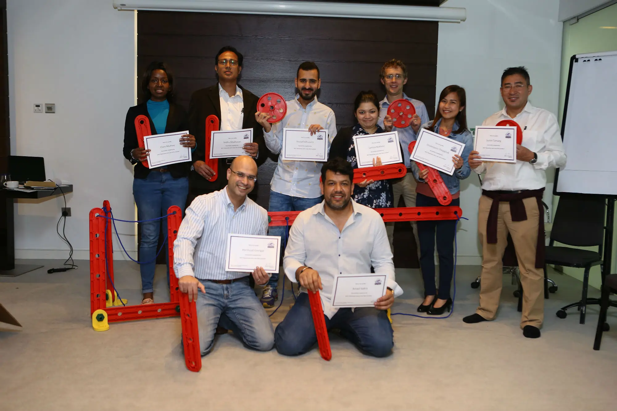 Group of participants at an MTa Masterclass proudly holding certificates, showcasing their progress in enhancing facilitation skills.