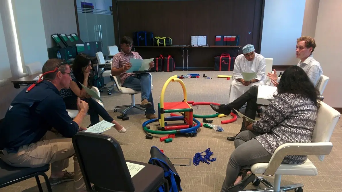 Facilitator engaging with participants, guiding reflection and discussion in an experiential learning session.