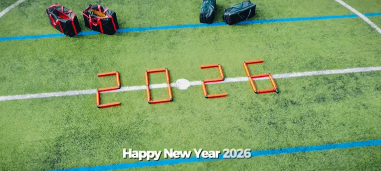 MTa pieces form "2026" on a sports field. Text at the bottom reads "Happy New Year 2026." MTa kit bags are seen in the background.