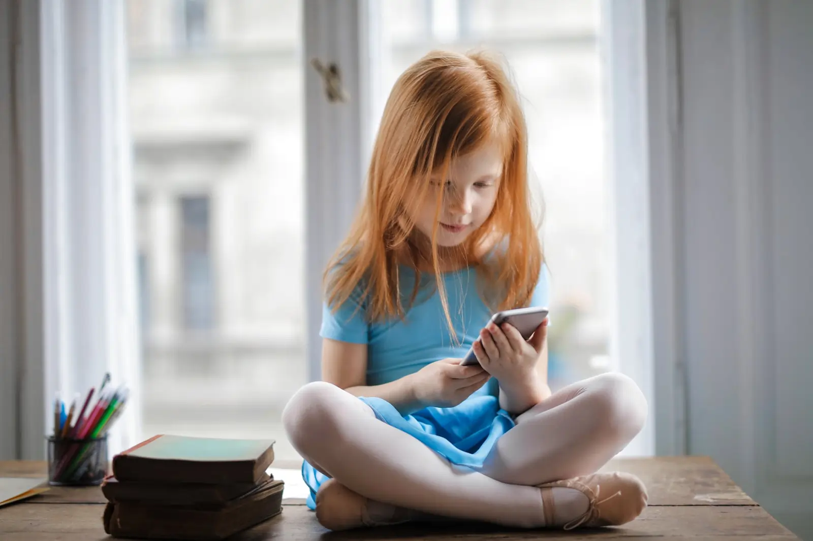 A child actively designing a mobile app on a smartphone, brainstorming solutions to environmental issues like reducing meat consumption, recycling, or using less plastic as part of a STEM activity.