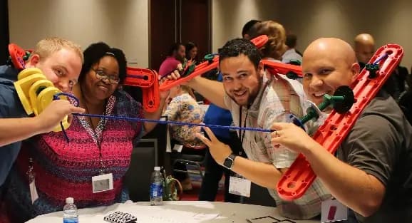 Group using MTa Kit for team development, enhancing collaboration, trust, and communication skills.